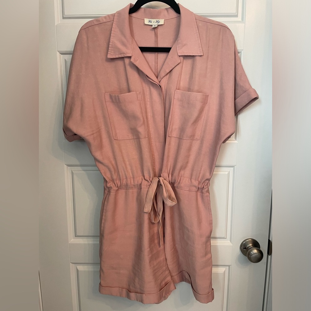 Dusty rose colored romper with hidden button top and cuffed sleeves/shorts.